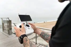 homme-commande-mobile-drone-plage